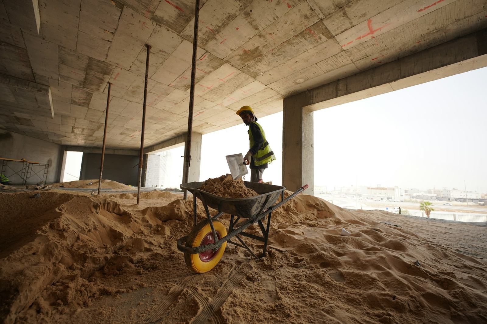 Construction worker moving sand on a building site